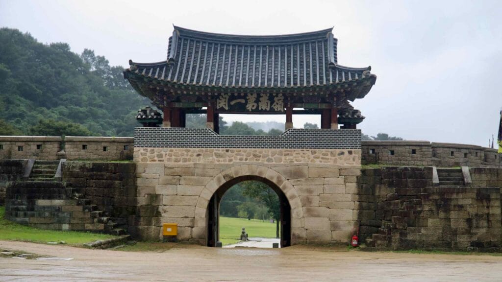 A Joseon-era gate pavilion rises above a stone arch at Mungyeong Saejae Provincial Park.