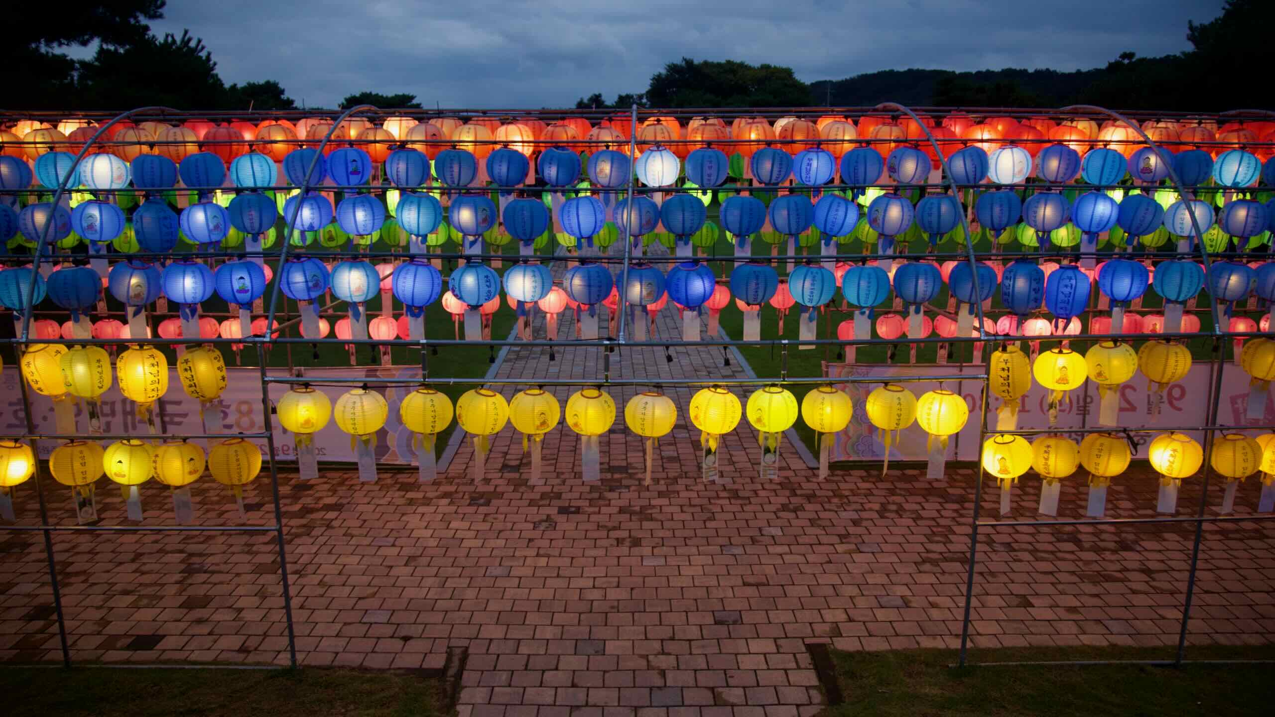 Tiered lantern rows span the front of Jungang Tower with a brick walkway leading in.