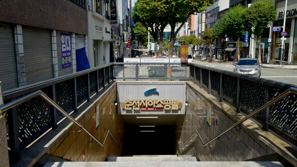 Stairways and railings lead down to the Chuncheon underground shopping mall entrance.