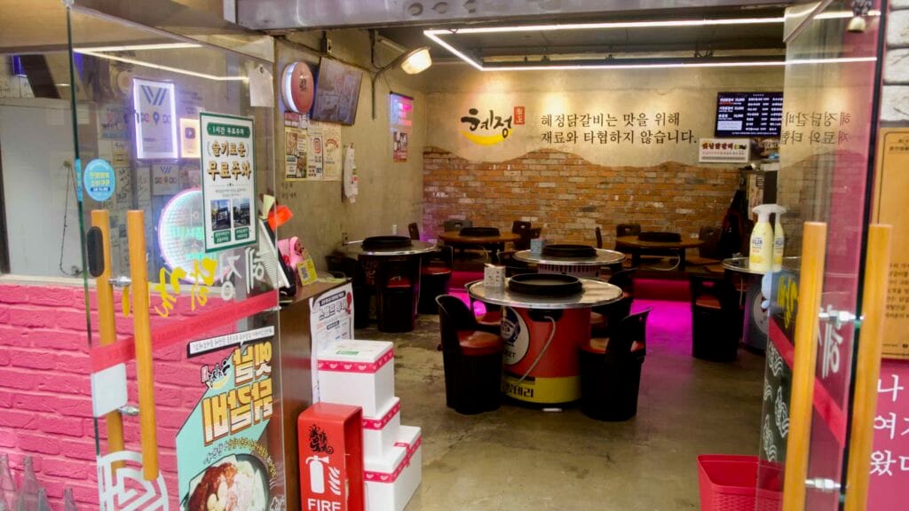 A dakgalbi restaurant interior with round metal griddle tables.