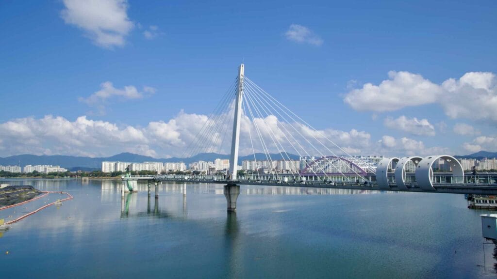 Chuncheon Bridge spans Uiam Lake with a single pylon, sweeping cables, and ring-like features along the deck.