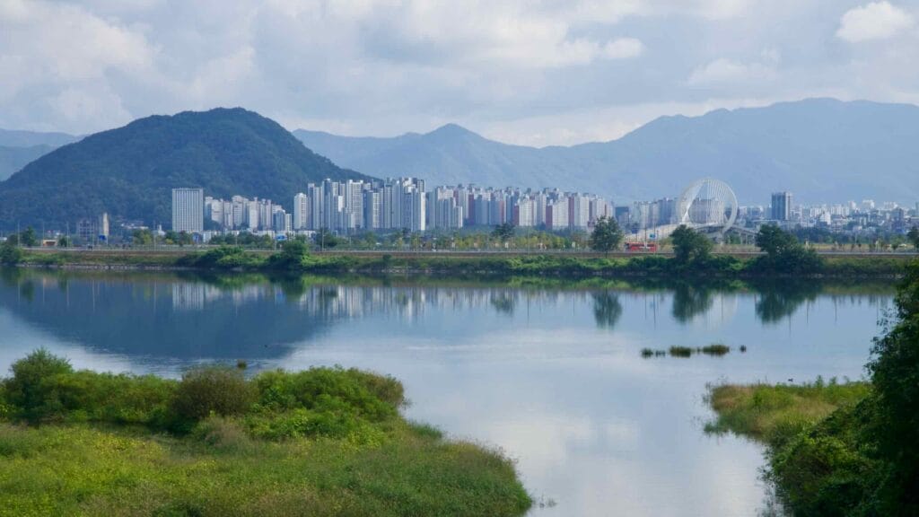 Apartments and Chuncheon Bridge’s ring pylon rise above calm Uiam Lake and distant hills.