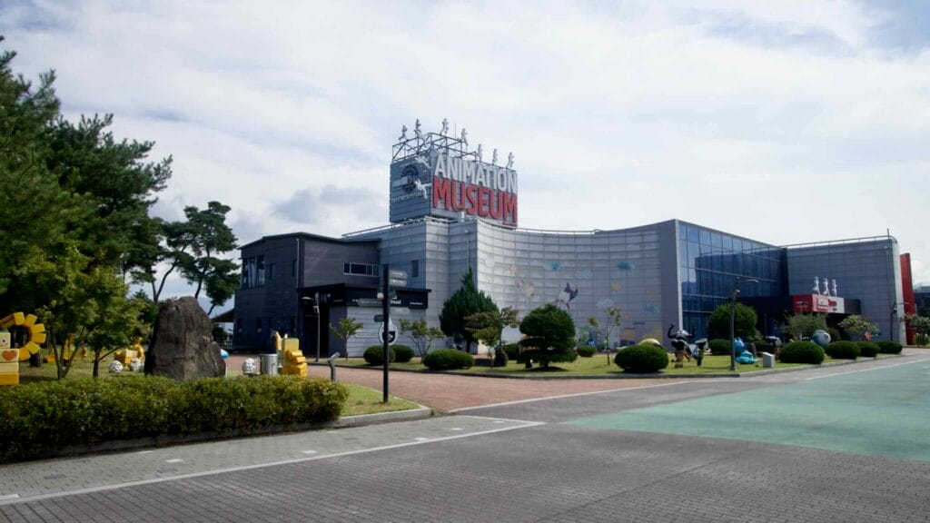 The Chuncheon Animation Museum’s playful facade and rooftop sign face a landscaped courtyard.
