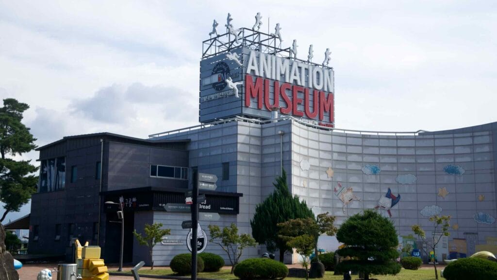 Rooftop sign and curving facade of Chuncheon’s Animation Museum above the plaza.