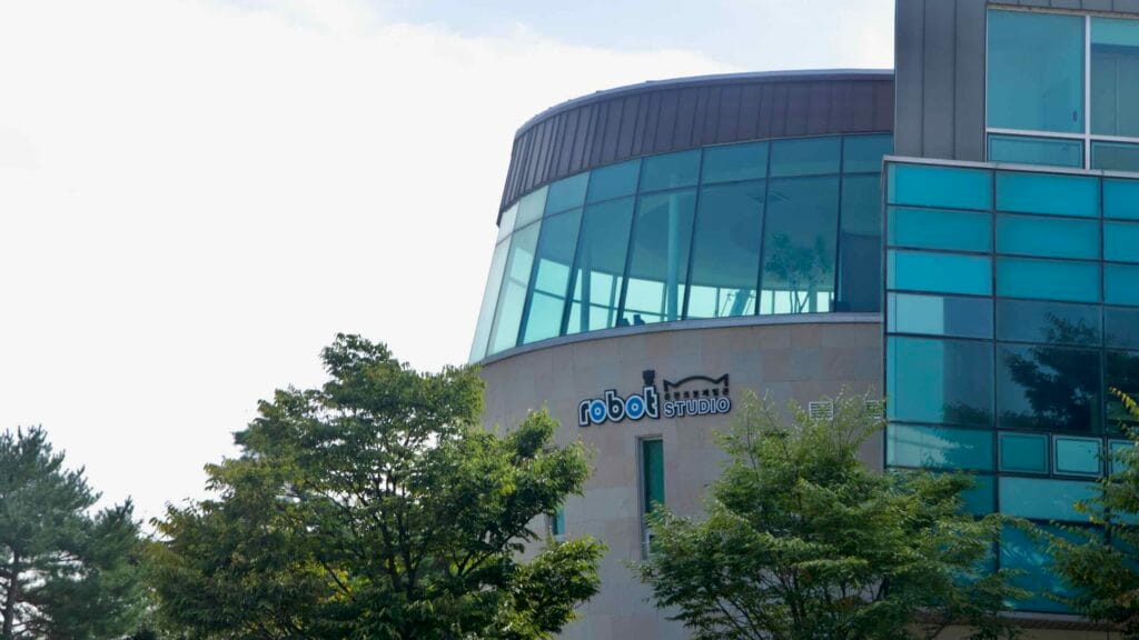 The glass rotunda of Robot Studio rises above trees beside Chuncheon’s Animation Museum.