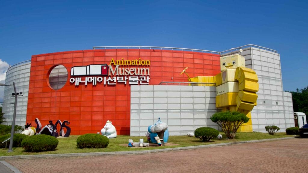 The red and white Animation Museum facade features a towering yellow robot sculpture at the entrance.
