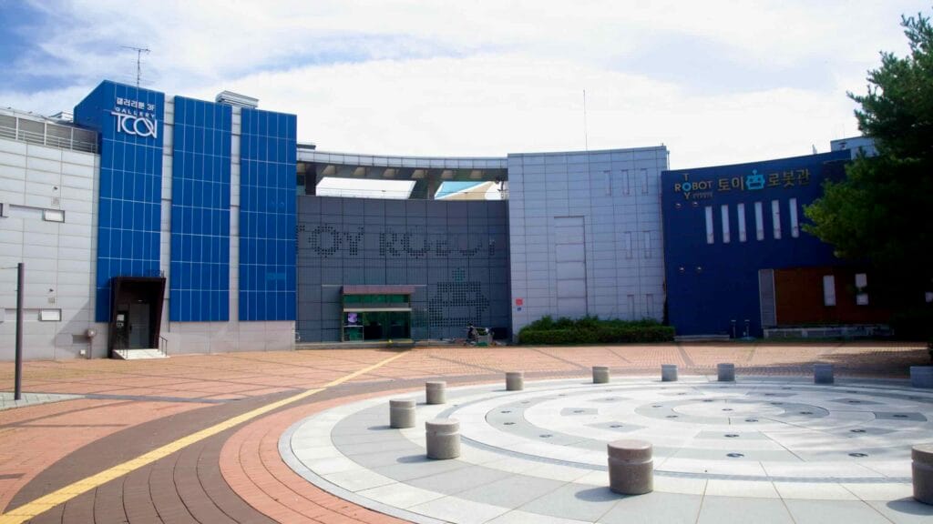 A broad courtyard lies between the Toy Robot Museum and Gallery TCON at Chuncheon’s museum park.