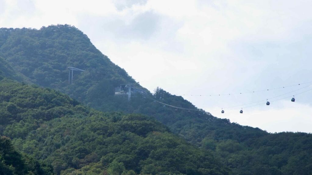Gondola cabins cross the valley near Samaksan above Uiam Lake.