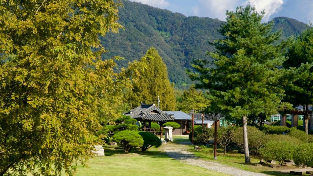 A traditional pavilion stands amid manicured lawns and pines near Jara Island in Gapyeong.