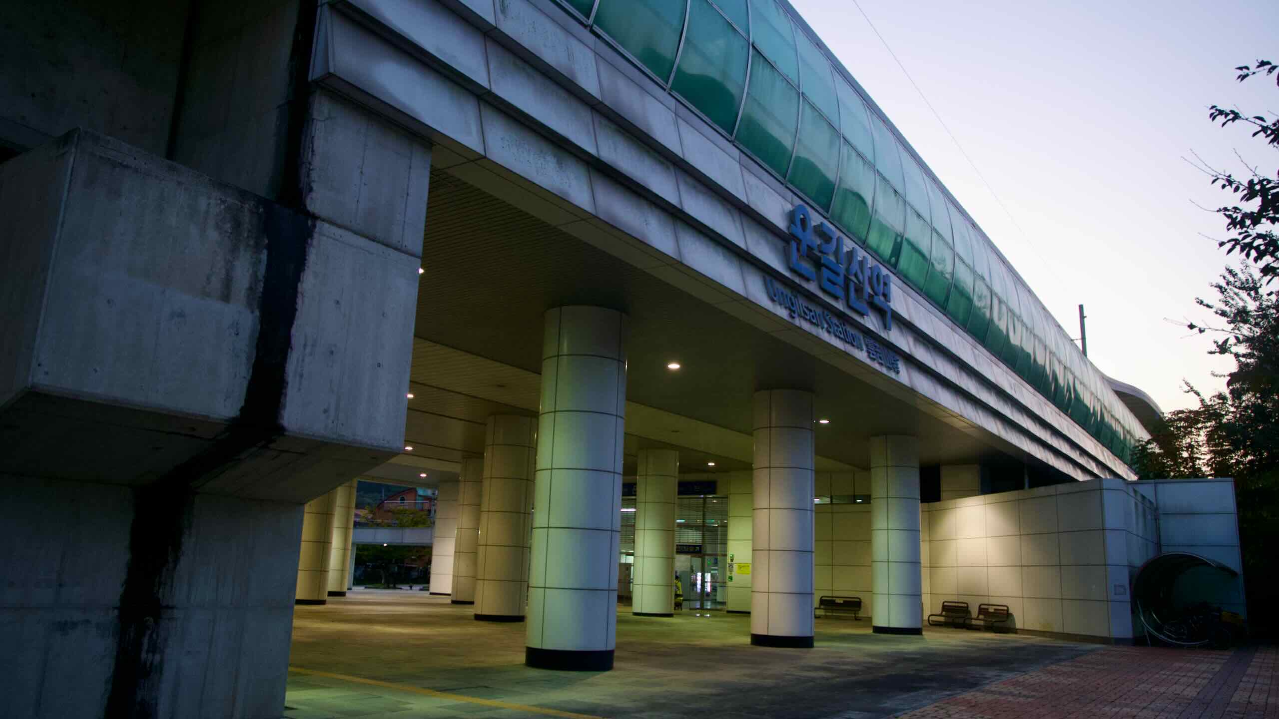 Ungilsan Station’s curved canopy and columned entrance glow at dusk in Namyangju.