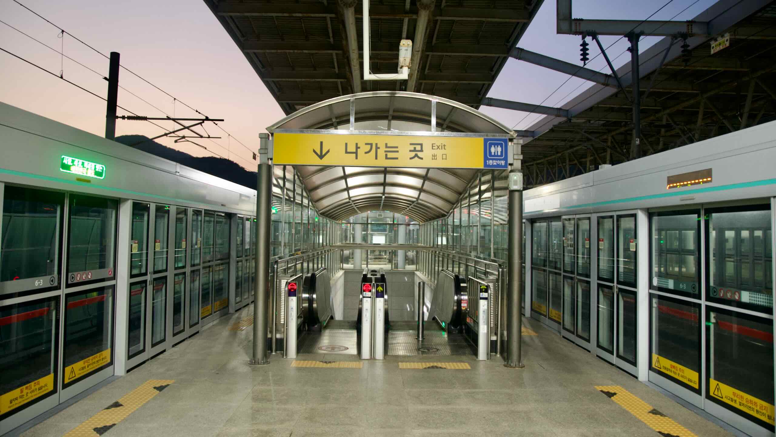 A covered walkway and screen doors lead to the exit at Ungilsan Station.