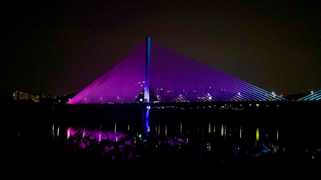 Violet and blue lights color the Guri-Amsa Bridge at night.