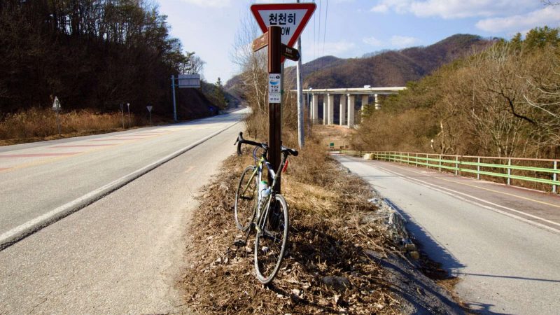 A picture of a bicycle laying at a switchback turn near the Seom River (섬강) on the Hangang Bike Path (한강자전거길) in Wongju City (원주시).