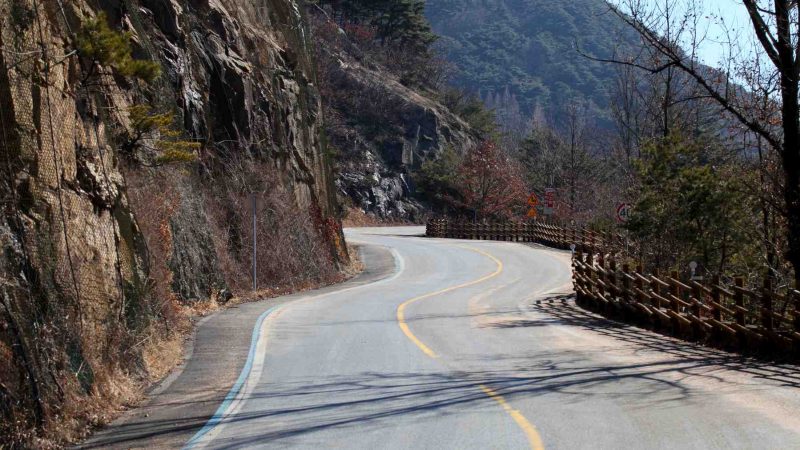 A picture of an empty road leading to the Ihwa Pass (이화령) on the Saejae Bicycle Path in Goesan County, South Korea.